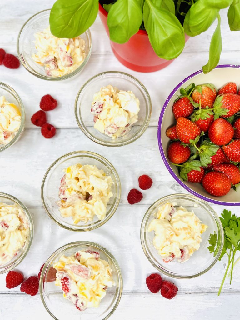 Eton mess with strawberries and mango served in small glass bowls