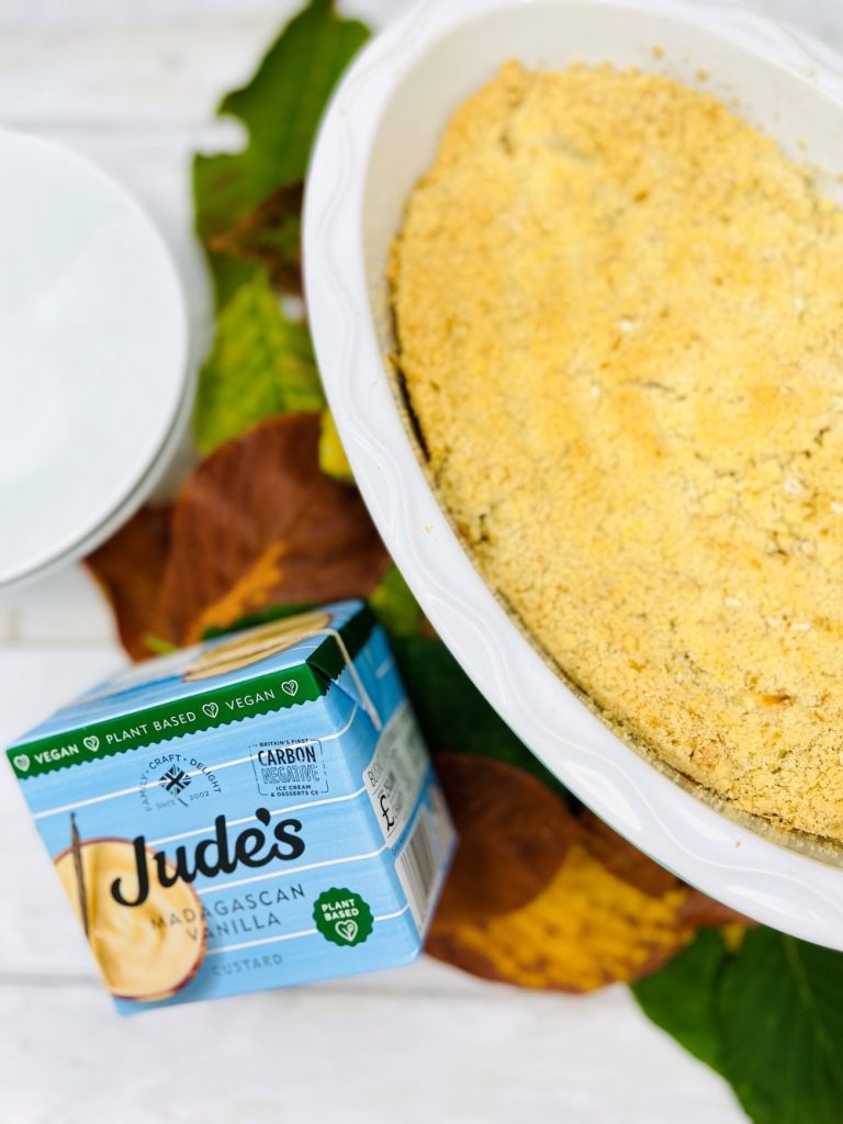 apple crumble recipe fresh from the oven next to a carton of Jude's plant based custard