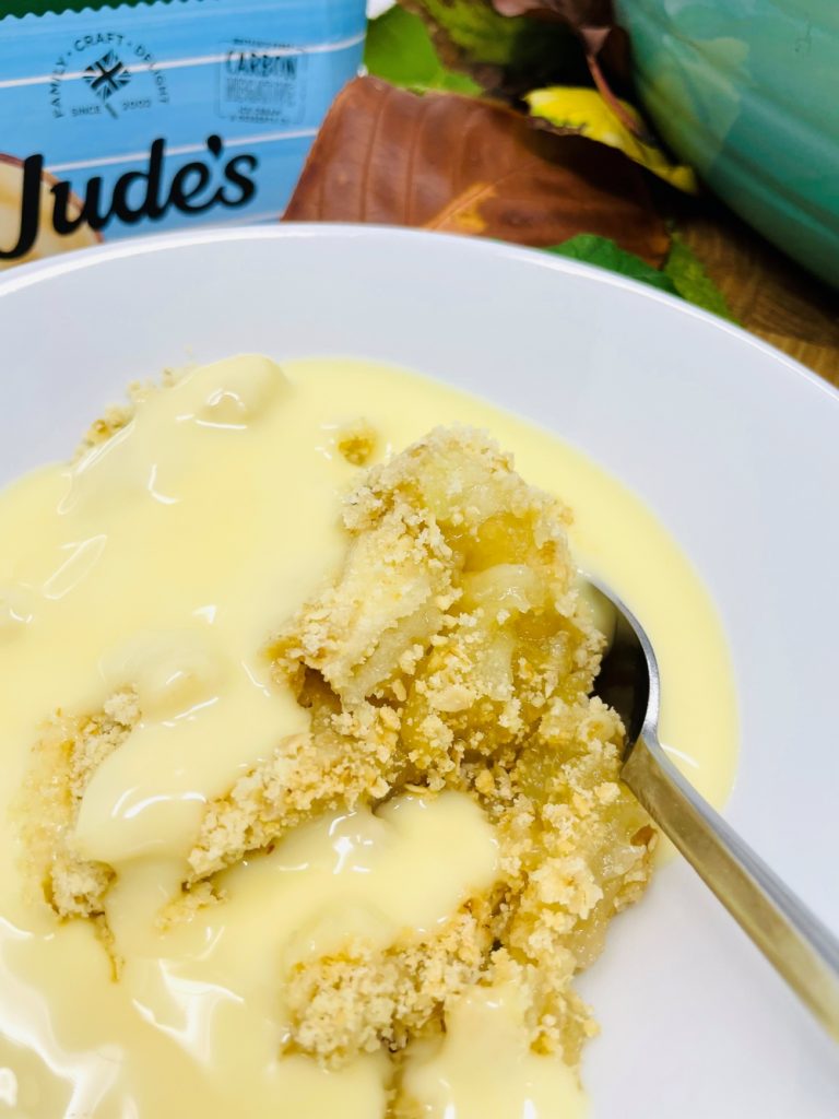 apple crumble recipe served in a bowl with lashings of Judes plant based custard