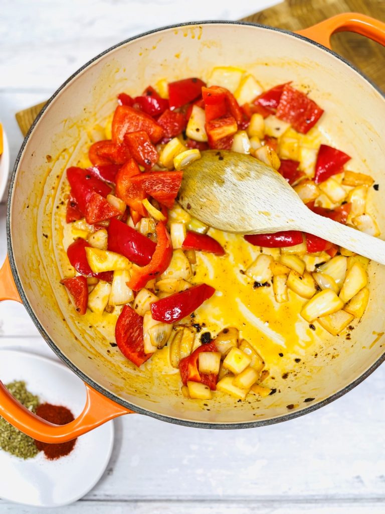 onions and peppers frying in chipotle paste in a skillet pan