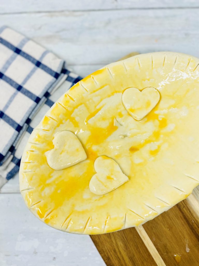 chicken pie decorated with love hearts from pastry, waiting to cook in the oven
