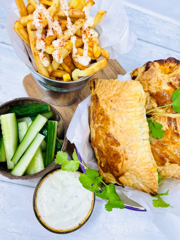 3 chicken tikka pasty in a serving bowl with bucket of French fries and cucumber sticks with dip