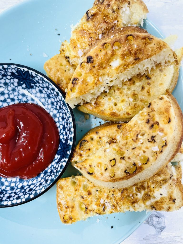 air fryer eggy bread crumpets served with tomato ketchup dip on blue patterned plate